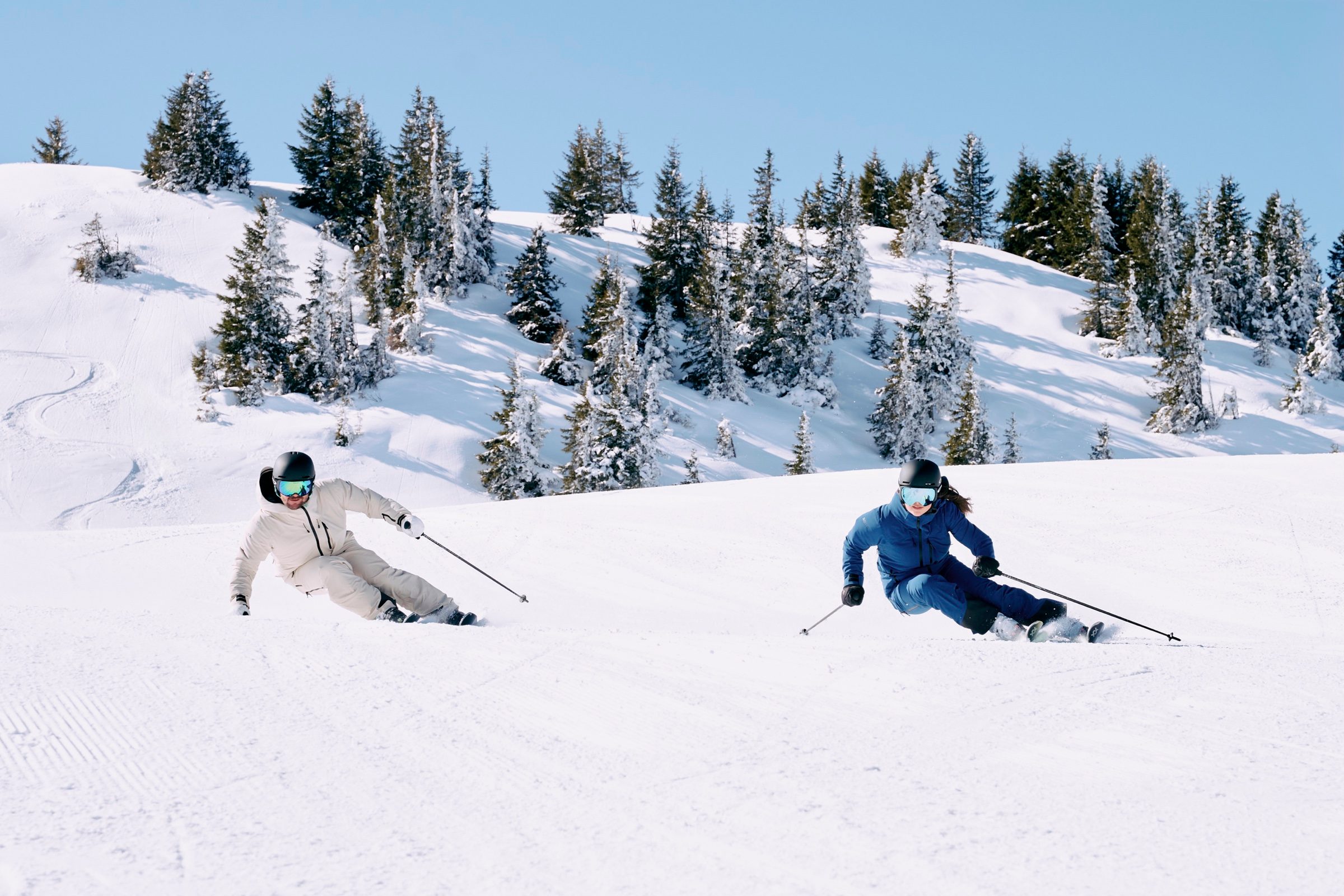 Zwei Skifahrer in der Carving-Kurve auf perfekt präparierter Piste im Paznaun