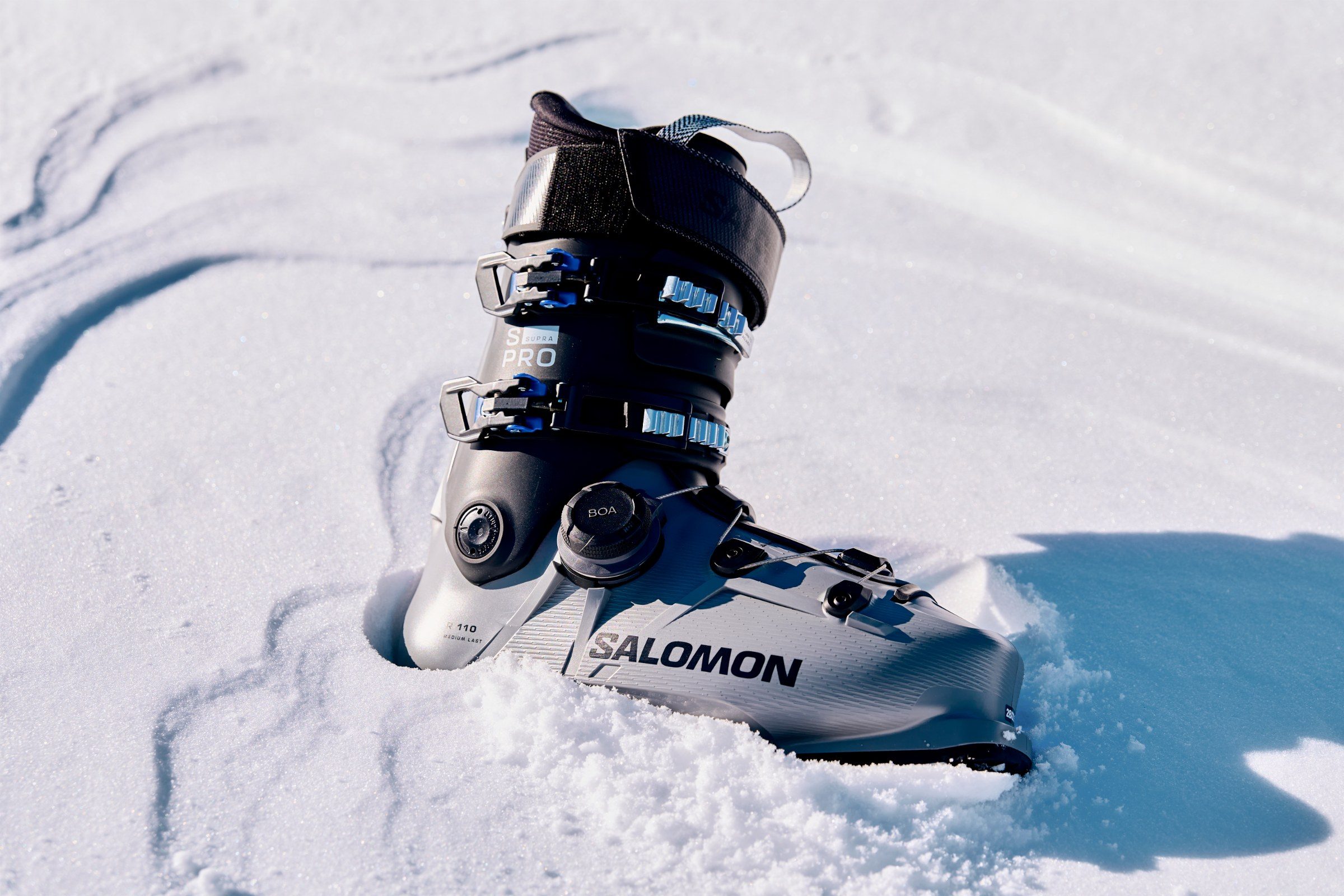 Salomon-Skischuh steht im frischen Schnee, Sonne von der Seite — INTERSPORT RENT Winter 2026/27