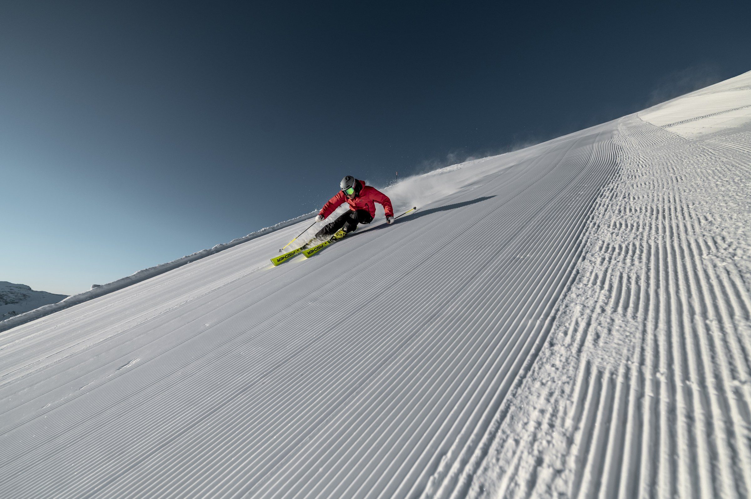 Ein Skifahrer zieht seine Schwünge über die frisch präparierte Piste im Skigebiet Ischgl