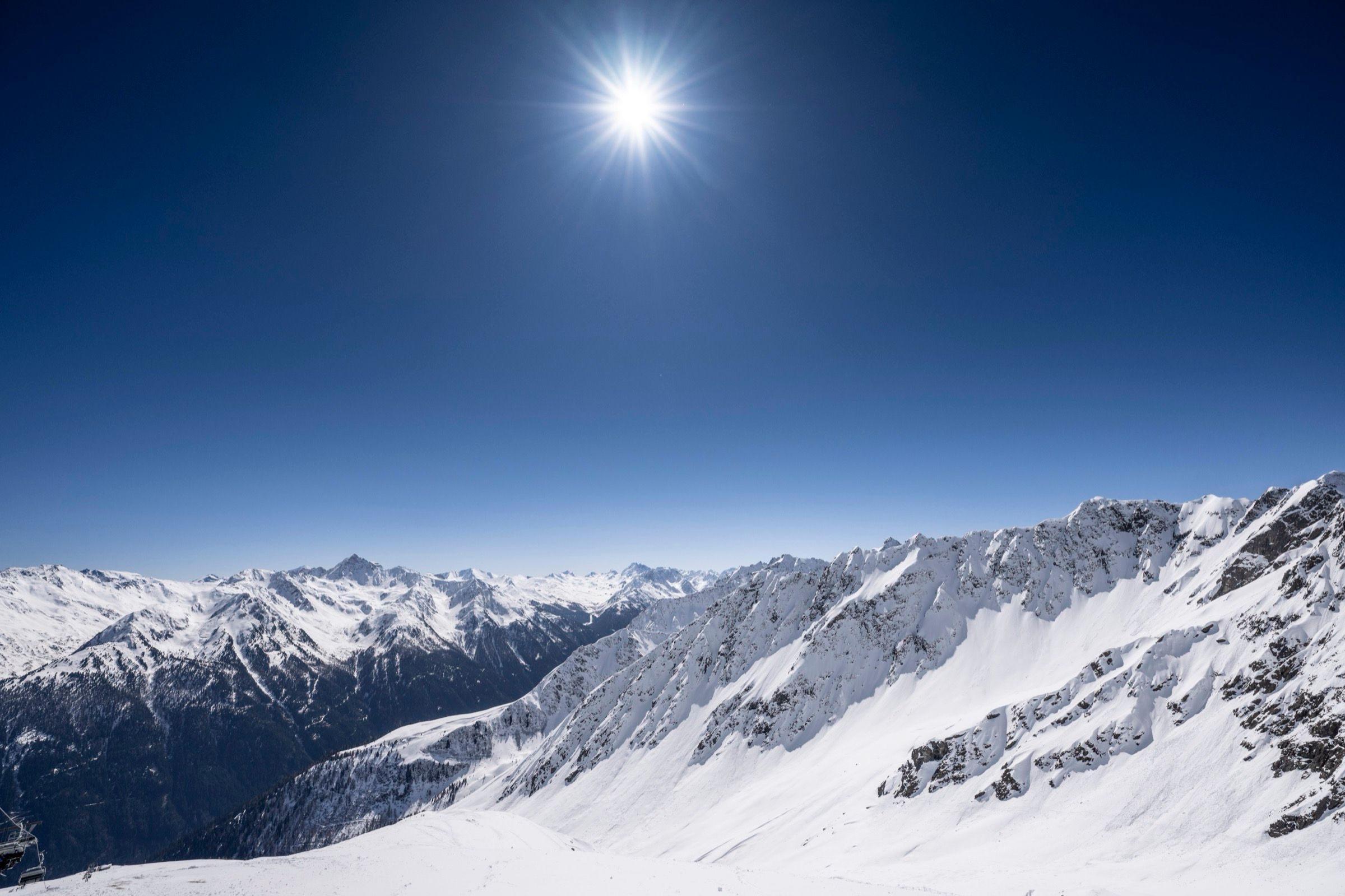 Sonnenstern über einem verschneiten Grat im Paznaun